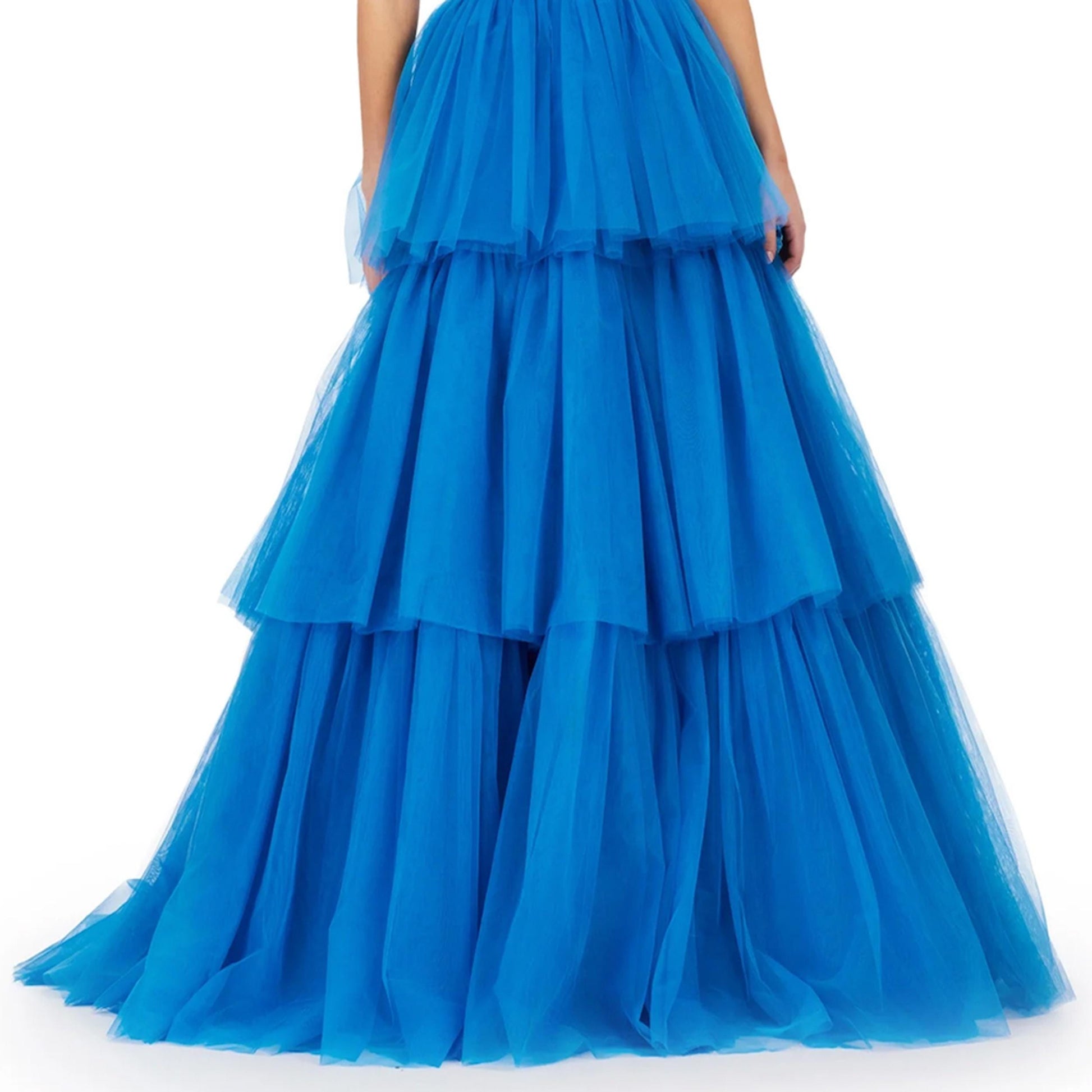 A close-up view of a woman wearing a blue, voluminous, tiered dress with a full skirt.