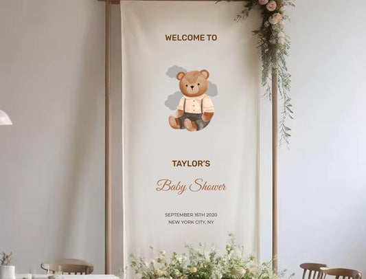 The image is a banner for a baby shower, featuring a teddy bear and text welcoming guests to Taylor&#39;s baby shower.