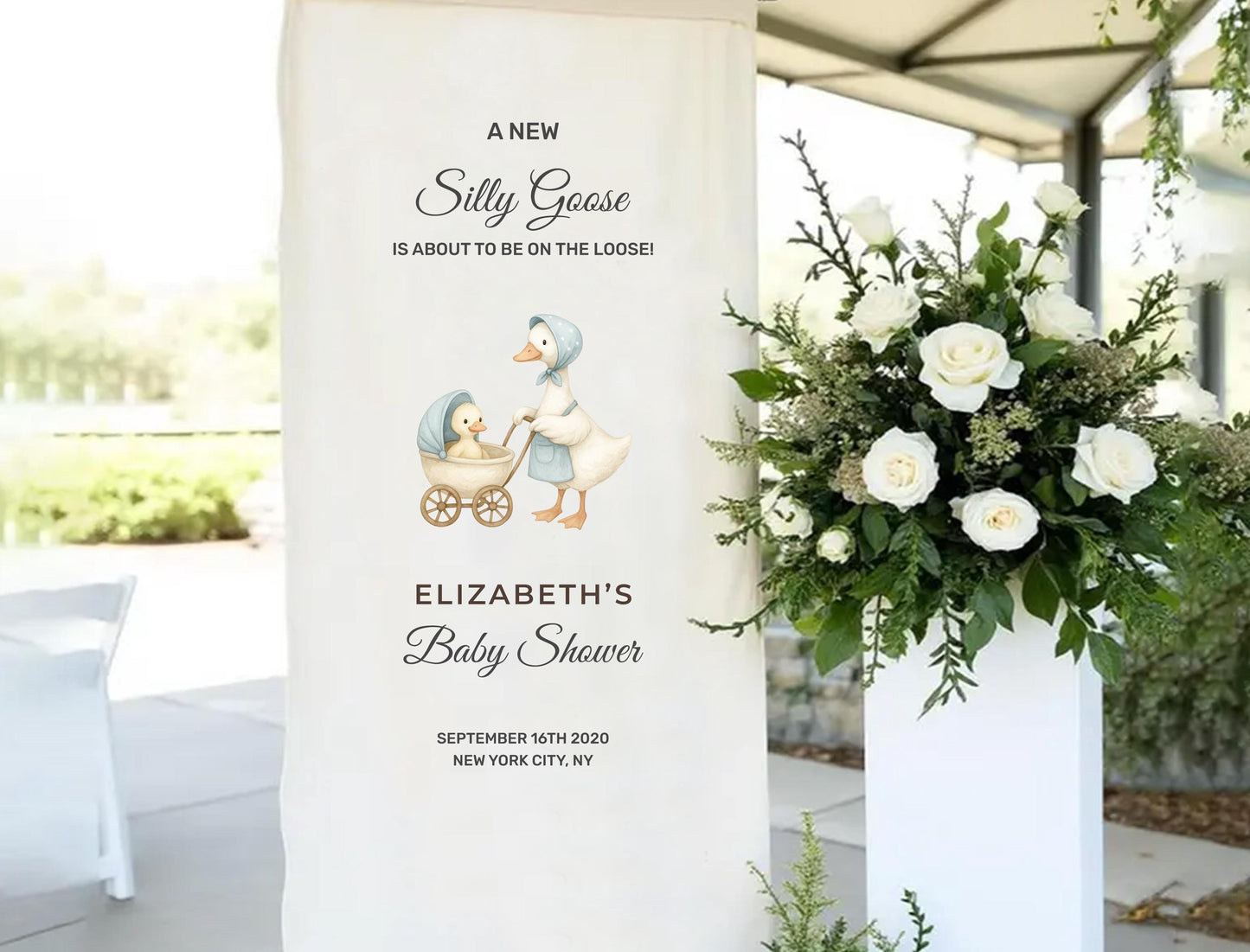 A banner for a baby shower event, featuring a cartoon image of a mother goose with her baby goose in a carriage, and a floral arrangement in a white vase.