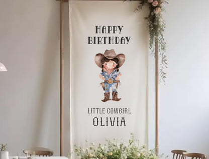 a banner with a cartoon cowboy character and text that reads &quot;Happy Birthday Little Cowgirl Olivia&quot;.