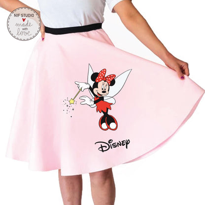 A woman is wearing a pink skirt with a Minnie Mouse design and the Disney logo.