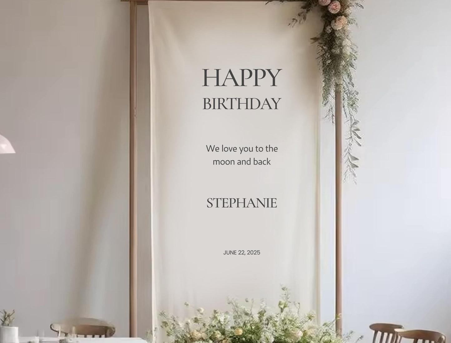 a banner with a message for Stephanie&#39;s birthday, hanging on a wall with floral decorations.
