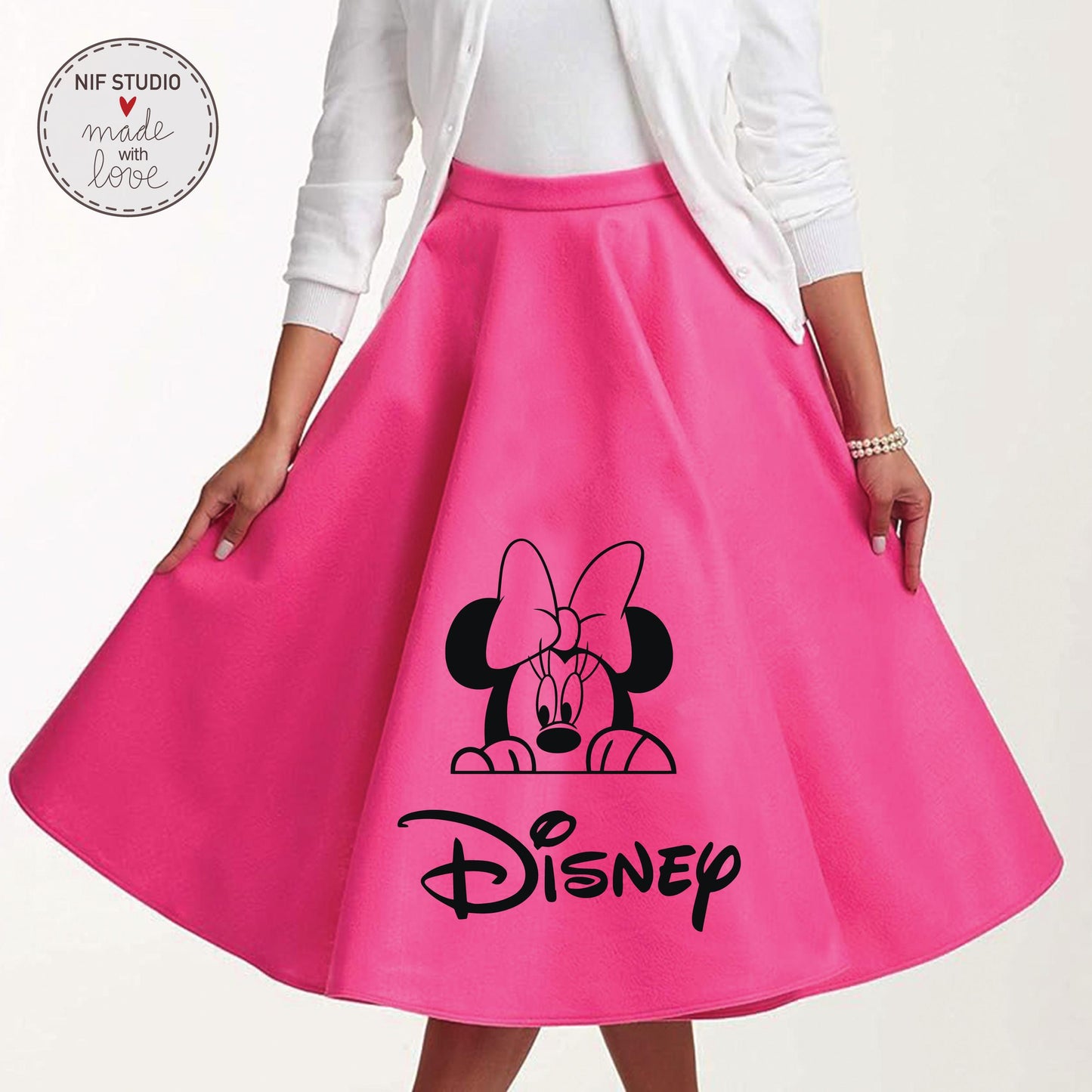 A woman wearing a bright pink skirt with a black Minnie Mouse graphic and the word &quot;Disney&quot; printed on it.