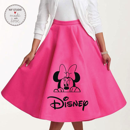 A woman wearing a bright pink skirt with a black Minnie Mouse graphic and the word &quot;Disney&quot; printed on it.