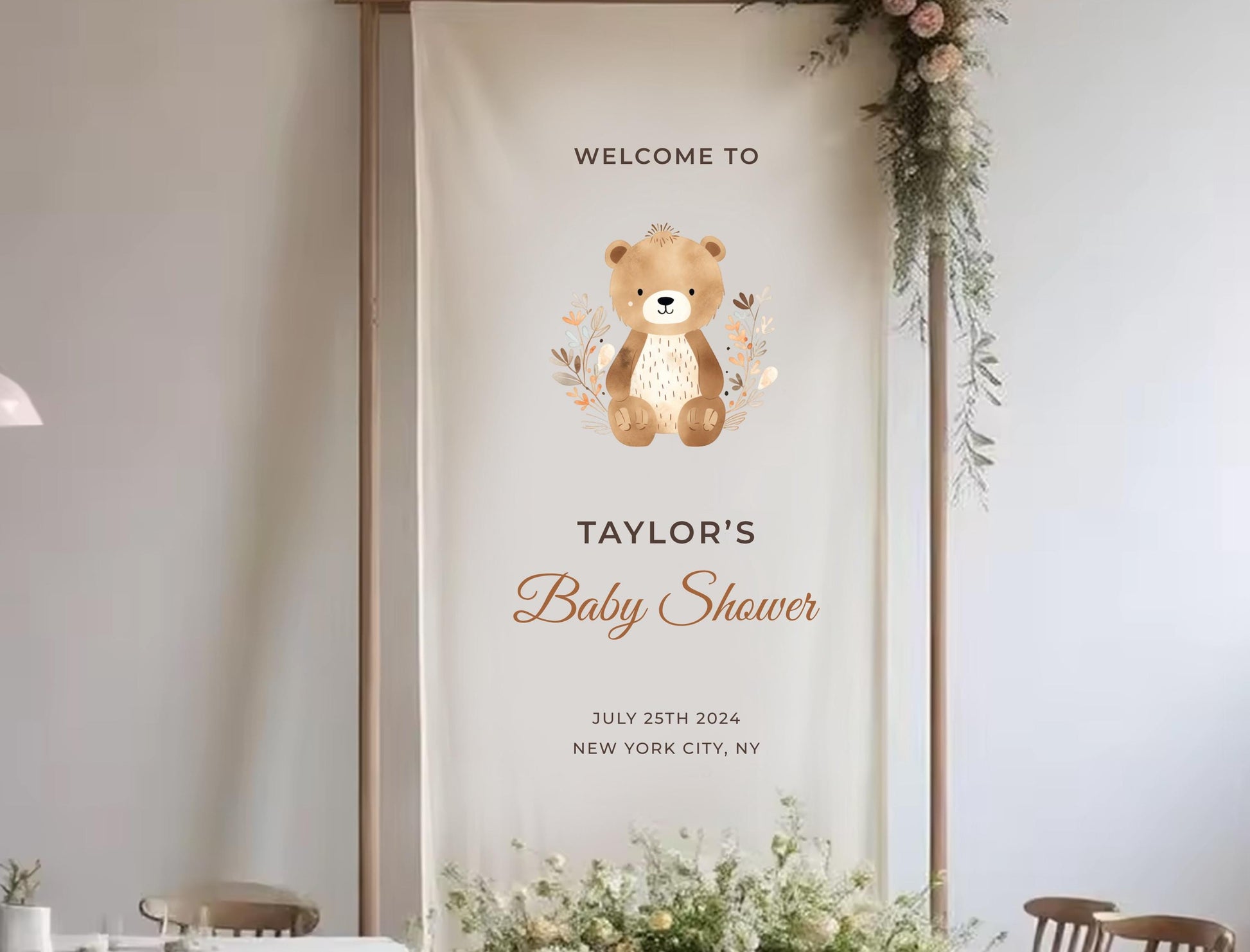 The image is a banner for a baby shower, featuring a teddy bear and floral decorations.