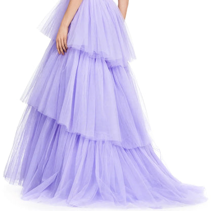 A woman wearing a long, voluminous, tiered purple dress with a flowing skirt.