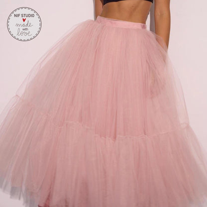 A woman wearing a large, pink tulle skirt.