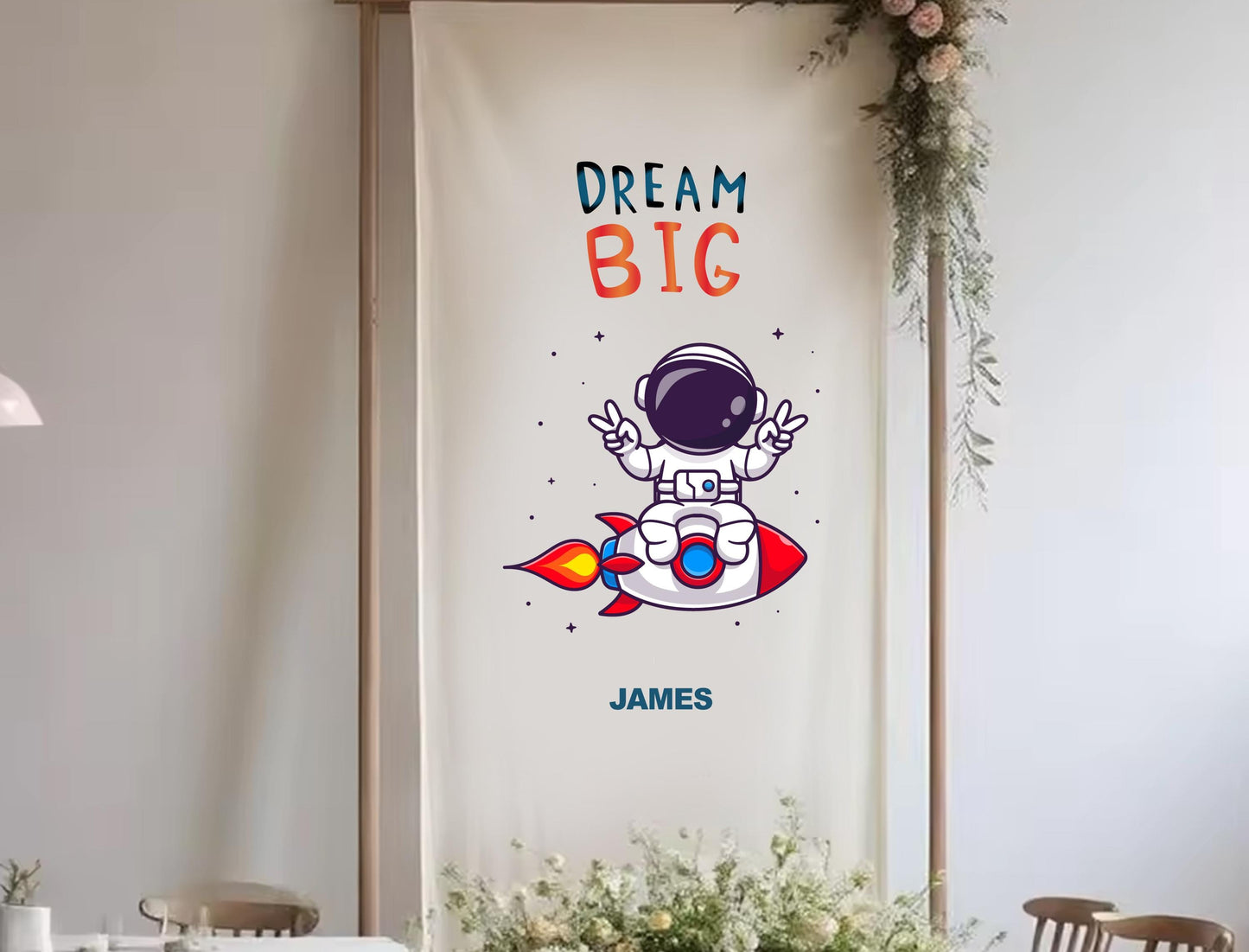 a banner with a cartoon astronaut and the text &quot;DREAM BIG&quot; along with the name &quot;JAMES&quot; below it.
