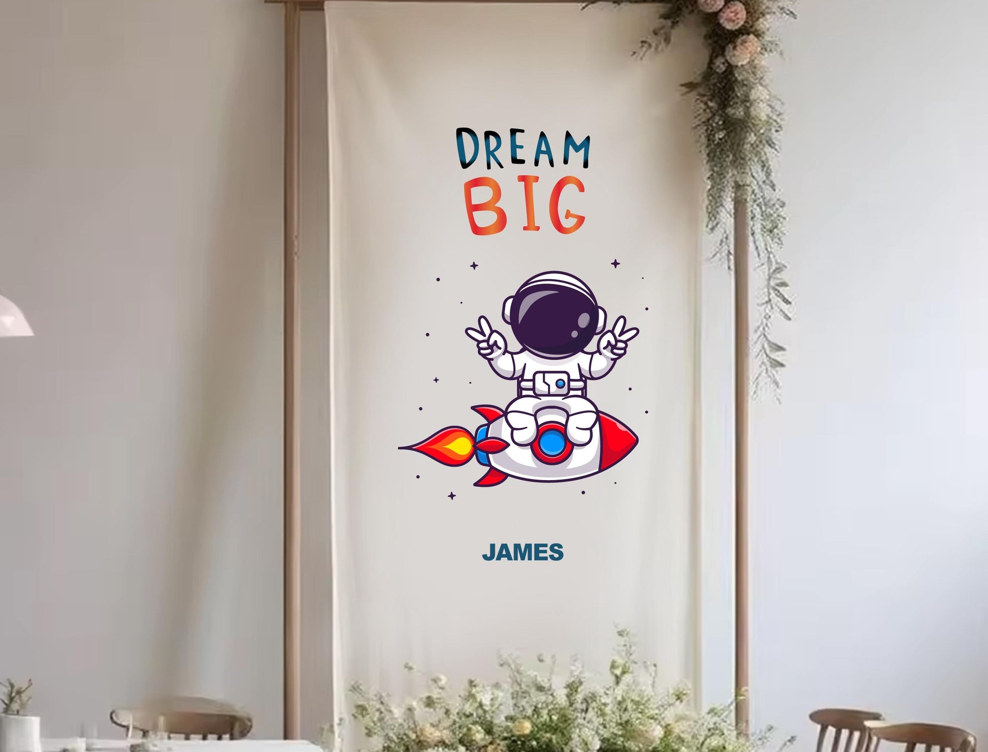 a banner with a cartoon astronaut and the text &quot;DREAM BIG&quot; along with the name &quot;JAMES&quot; below it.