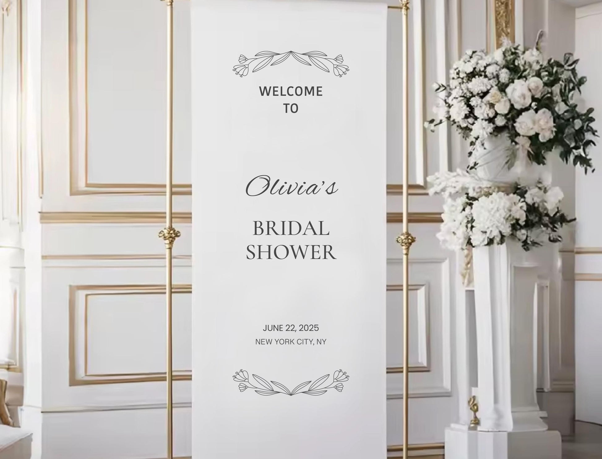 a white banner with black text and decorative elements, placed in a room with a floral arrangement on a pedestal.