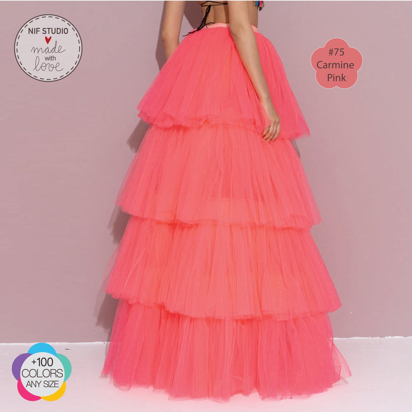 a woman in a long pink dress standing in front of a wall