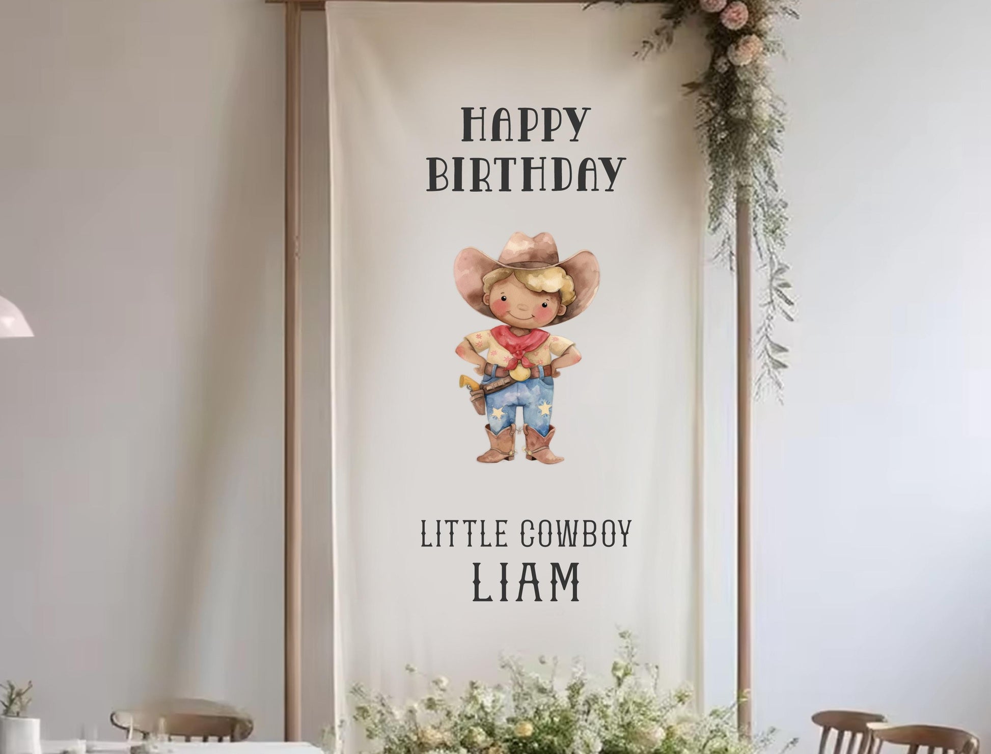 A banner with a cartoon cowboy character and the text &quot;Happy Birthday Little Cowboy Liam&quot; hanging on a wall.
