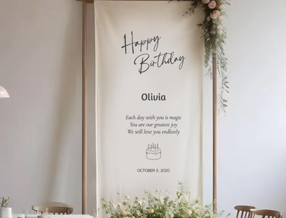 a banner with a birthday message for a person named Olivia. The banner has a white background with black text and a small illustration of a cake.