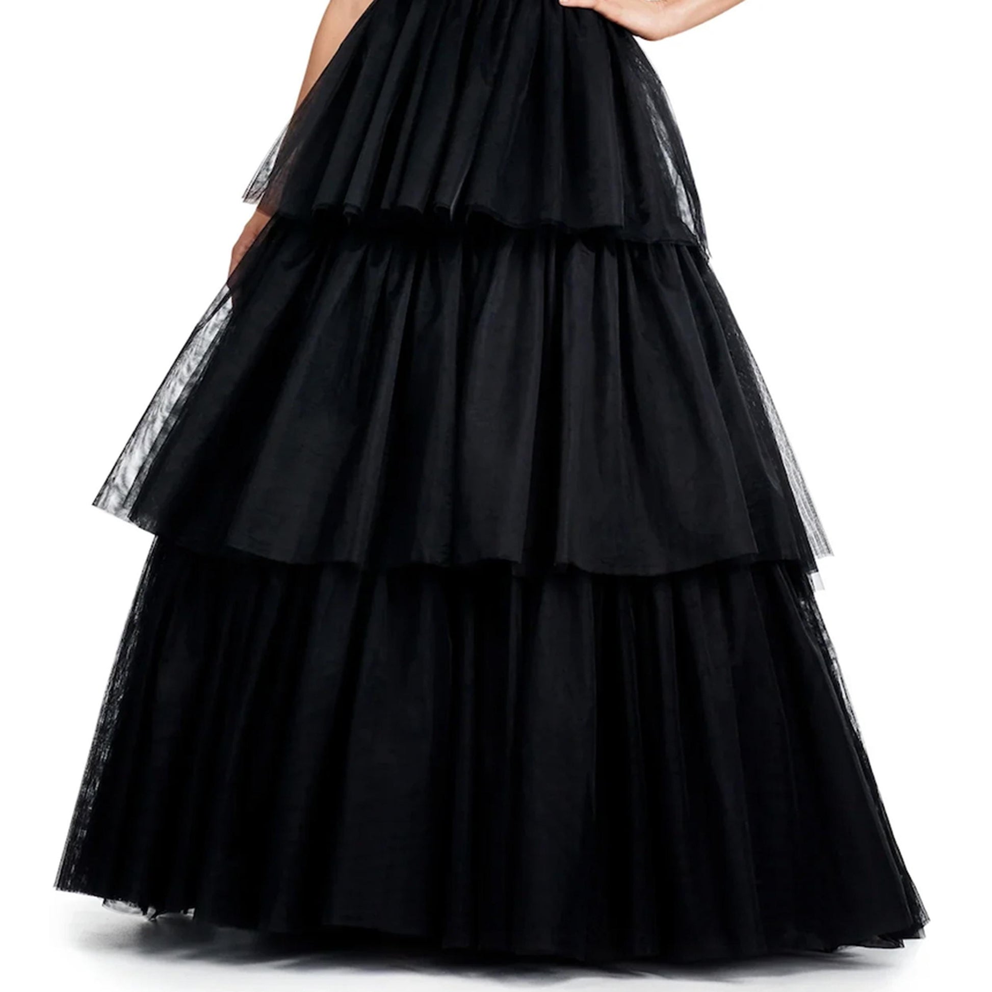 A woman wearing a long, black, ruffled skirt with multiple layers.